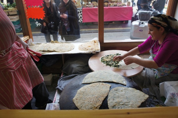 A Turkish lady and man make gozlenes, kind of a Turkish roti stuffed with cheese and spinach